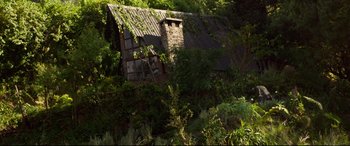Movie still from “Siberia” (2020), directed by Abel Ferrara – An old house with a brick chimney in the middle of a forest; Extreme Wide shot, Low angle