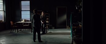 Movie still from “Siberia” (2020), directed by Abel Ferrara – Two people are standing in a dark room; Wide shot, High angle