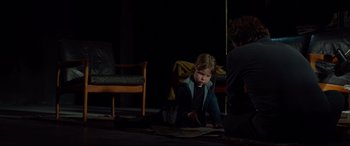Movie still from “Siberia” (2020), directed by Abel Ferrara – A little girl sitting on the floor in a dark room; Medium shot, Over the shoulder angle