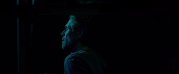 Movie still from “Siberia” (2020), directed by Abel Ferrara – A man with a beard is in the dark looking up; Close Up shot, Low angle