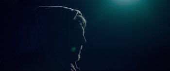 Movie still from “Siberia” (2020), directed by Abel Ferrara – A man with a beard is looking into the distance; Close Up shot, Low angle