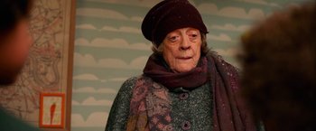 Movie still from “A Boy Called Christmas” (2021), directed by Gil Kenan – An older woman wearing a hat and a scarf; Close Up shot, Low angle