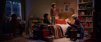 Movie still from “A Boy Called Christmas” (2021), directed by Gil Kenan – Two children are standing in a room with a bed and books; Wide shot, High angle