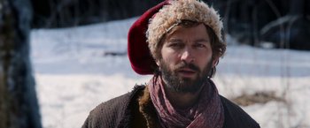 Movie still from “A Boy Called Christmas” (2021), directed by Gil Kenan – A man with a beard wearing a hat and scarf; Close Up shot, Over the shoulder angle