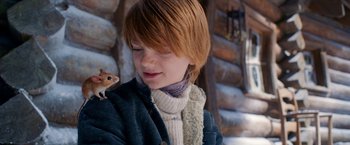 Movie still from “A Boy Called Christmas” (2021), directed by Gil Kenan – A young boy holding a mouse on his shoulder; Close Up shot, Low angle