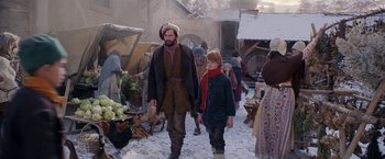 Movie still from “A Boy Called Christmas” (2021), directed by Gil Kenan – A man and a boy walking down a street; Wide shot, Over the shoulder angle