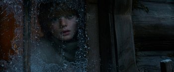 Movie still from “A Boy Called Christmas” (2021), directed by Gil Kenan – A young person looking out of a window at night; Close Up shot, Low angle