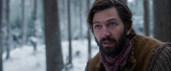 Movie still from “A Boy Called Christmas” (2021), directed by Gil Kenan – A person with a beard wearing a scarf; Close Up shot, Over the shoulder angle