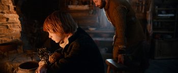 Movie still from “A Boy Called Christmas” (2021), directed by Gil Kenan – A man standing next to a child in a room; Medium shot, Over the shoulder angle