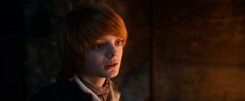 Movie still from “A Boy Called Christmas” (2021), directed by Gil Kenan – A boy with red hair is looking at the camera; Close Up shot, Low angle
