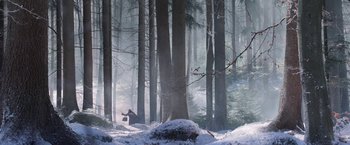Movie still from “A Boy Called Christmas” (2021), directed by Gil Kenan – A person is standing in the snow near a tree; Extreme Wide shot, Low angle