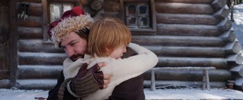 Movie still from “A Boy Called Christmas” (2021), directed by Gil Kenan – A man and a girl hug in front of a log cabin; Close Up shot, Over the shoulder angle