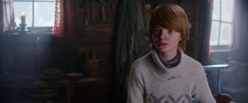 Movie still from “A Boy Called Christmas” (2021), directed by Gil Kenan – A person wearing a white sweater standing in a room; Close Up shot, Over the shoulder angle