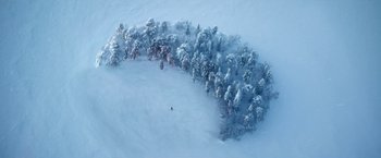 Movie still from “A Boy Called Christmas” (2021), directed by Gil Kenan – An aerial view of a person skiing in the snow; Extreme Wide shot, Overhead angle