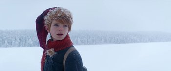 Movie still from “A Boy Called Christmas” (2021), directed by Gil Kenan – A young girl wearing a hat and scarf in the snow; Medium shot, Low angle