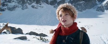 Movie still from “A Boy Called Christmas” (2021), directed by Gil Kenan – A young woman wearing a red scarf and a red hat; Close Up shot, Low angle