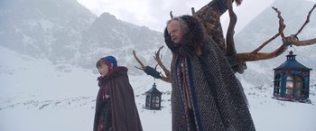 Movie still from “A Boy Called Christmas” (2021), directed by Gil Kenan – A man and a child in a snowy field; Medium shot, Low angle