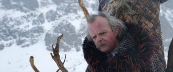 Movie still from “A Boy Called Christmas” (2021), directed by Gil Kenan – An old man with a beard and a fur coat on; Close Up shot, Low angle