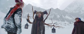 Movie still from “A Boy Called Christmas” (2021), directed by Gil Kenan – An old man in a fur coat and a tree branch; Wide shot, Low angle