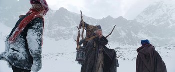 Movie still from “A Boy Called Christmas” (2021), directed by Gil Kenan – An old man with a beard is standing in the snow; Wide shot, Low angle