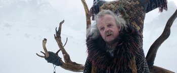 Movie still from “A Boy Called Christmas” (2021), directed by Gil Kenan – A man with a beard and a fur coat on; Close Up shot, Low angle