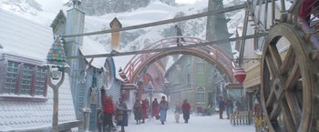 Movie still from “A Boy Called Christmas” (2021), directed by Gil Kenan – A group of people walking down a snow covered street; Extreme Wide shot, High angle