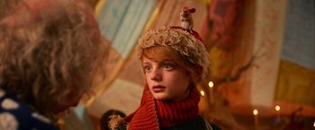 Movie still from “A Boy Called Christmas” (2021), directed by Gil Kenan – A woman wearing a hat with a mouse on top of her head; Close Up shot, Low angle
