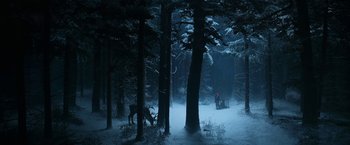 Movie still from “A Boy Called Christmas” (2021), directed by Gil Kenan – A man is standing in the snow near a forest; Extreme Wide shot, High angle