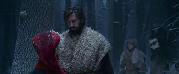 Movie still from “A Boy Called Christmas” (2021), directed by Gil Kenan – A bearded man in a fur coat is talking to a woman in a forest; Medium shot, Over the shoulder angle