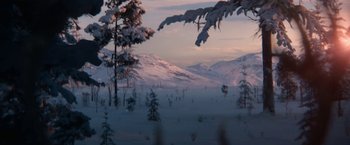 Movie still from “A Boy Called Christmas” (2021), directed by Gil Kenan – A view of a snow covered mountain range with trees in the foreground; Extreme Wide shot, High angle