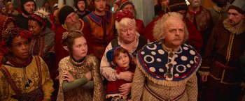 Movie still from “A Boy Called Christmas” (2021), directed by Gil Kenan – A group of people dressed up in costumes; Medium shot, Over the shoulder angle