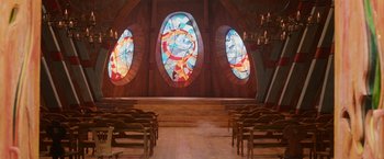 Movie still from “A Boy Called Christmas” (2021), directed by Gil Kenan – A church with stained glass windows and wooden pedestals; Extreme Wide shot, High angle
