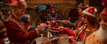 Movie still from “A Boy Called Christmas” (2021), directed by Gil Kenan – A group of people in a room with a child in a costume; Medium shot, High angle