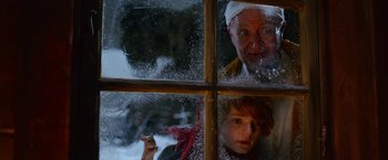 Movie still from “A Boy Called Christmas” (2021), directed by Gil Kenan – A man and a child looking out a window; Close Up shot, Low angle