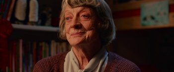 Movie still from “A Boy Called Christmas” (2021), directed by Gil Kenan – An older woman with a white shirt and a red sweater; Close Up shot, Over the shoulder angle