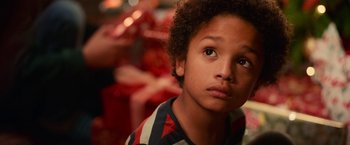 Movie still from “A Boy Called Christmas” (2021), directed by Gil Kenan – A young boy with a red and black shirt on; Close Up shot, Over the shoulder angle