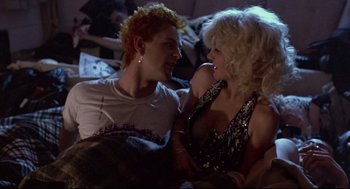 Movie still from “Sid and Nancy” (1986), directed by Alex Cox – A man and a woman sitting next to each other; Medium shot, Low angle
