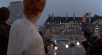Movie still from “Sid and Nancy” (1986), directed by Alex Cox – A man standing in front of a building at night; Wide shot, Low angle