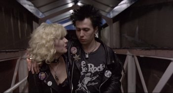 Movie still from “Sid and Nancy” (1986), directed by Alex Cox – A man and a woman wearing leather jackets; Medium shot, Over the shoulder angle