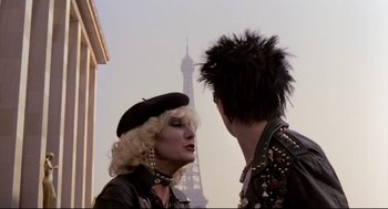 Movie still from “Sid and Nancy” (1986), directed by Alex Cox – A man and a woman are talking in front of the eiffel tower; Medium shot, Over the shoulder angle
