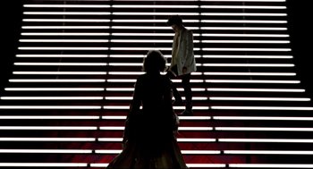 Movie still from “Sid and Nancy” (1986), directed by Alex Cox – Two people walking up a set of stairs; Wide shot, Low angle