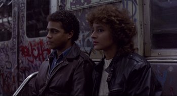 Movie still from “Sid and Nancy” (1986), directed by Alex Cox – A man and a woman are standing next to each other; Medium shot, High angle