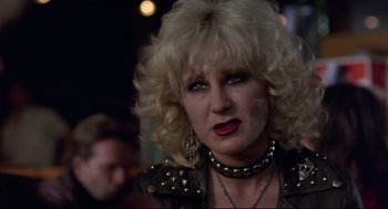 Movie still from “Sid and Nancy” (1986), directed by Alex Cox – A person wearing a leather jacket; Close Up shot, Over the shoulder angle