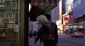 Movie still from “Sid and Nancy” (1986), directed by Alex Cox – A woman in a black jacket and a man in a black jacket; Wide shot, Over the shoulder angle