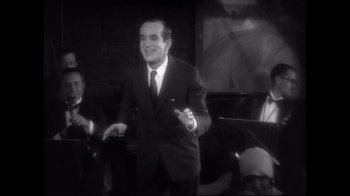 Movie still from “Side by Side” (2012), directed by Christopher Kenneally – A man in a black suit and a white tie; Medium shot, High angle