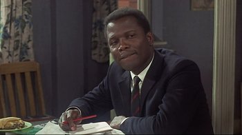 Movie still from “Side by Side” (2012), directed by Christopher Kenneally – A man sitting at a table writing on a piece of paper; Close Up shot, Over the shoulder angle