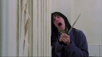 Movie still from “Side by Side” (2012), directed by Christopher Kenneally – A woman holding a knife and looking surprised; Medium shot, Low angle