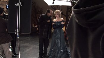 Movie still from “Side by Side” (2012), directed by Christopher Kenneally – A man standing next to a woman wearing a dress; Medium shot, Over the shoulder angle