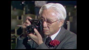 Movie still from “Side by Side” (2012), directed by Christopher Kenneally – An older man taking a picture with a camera; Close Up shot, Low angle
