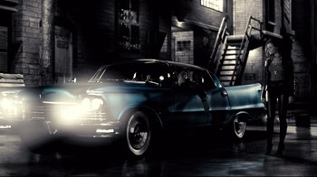 Movie still from “Side by Side” (2012), directed by Christopher Kenneally – An old car is driving down the street; Wide shot, Low angle